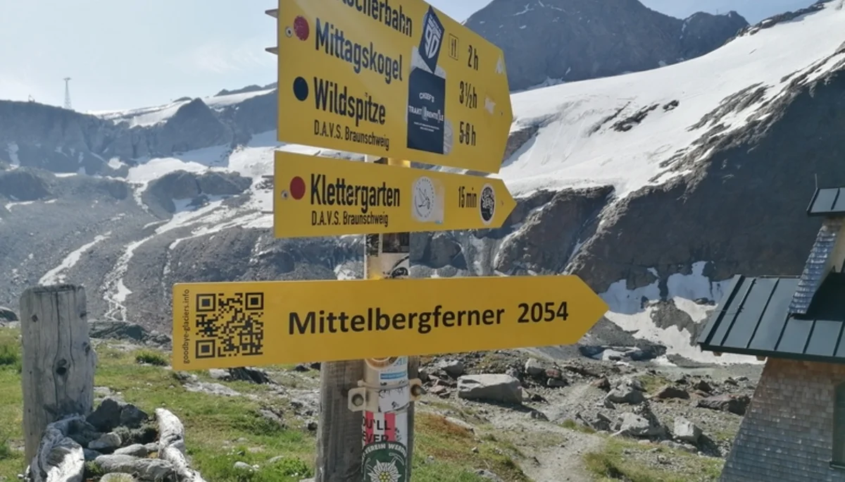 Der Wegweiser neben der Braunschweiger Hütte zeigt auf den Mittelbergferner und dessen prognostizierten Rückgang bis 2054. Ein QR-Code verweist auf goodbye-glaciers.info. | © Günter Gehrke