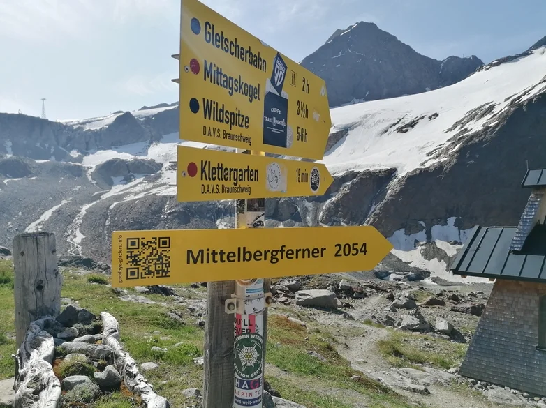 Der Wegweiser neben der Braunschweiger Hütte zeigt auf den Mittelbergferner und dessen prognostizierten Rückgang bis 2054. Ein QR-Code verweist auf goodbye-glaciers.info. | © Günter Gehrke