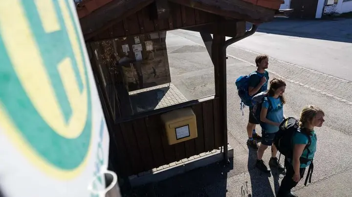 Drei Jugendliche mit Wanderrucksäcken stehen an einer Bushaltestelle | © DAV/Wolfgang Ehn