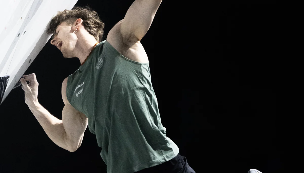 Thorben hängt in einem steilen Boulder, beide Beine pendeln dabei aus der Wand. | © Kazushige Nakajima/IFSC