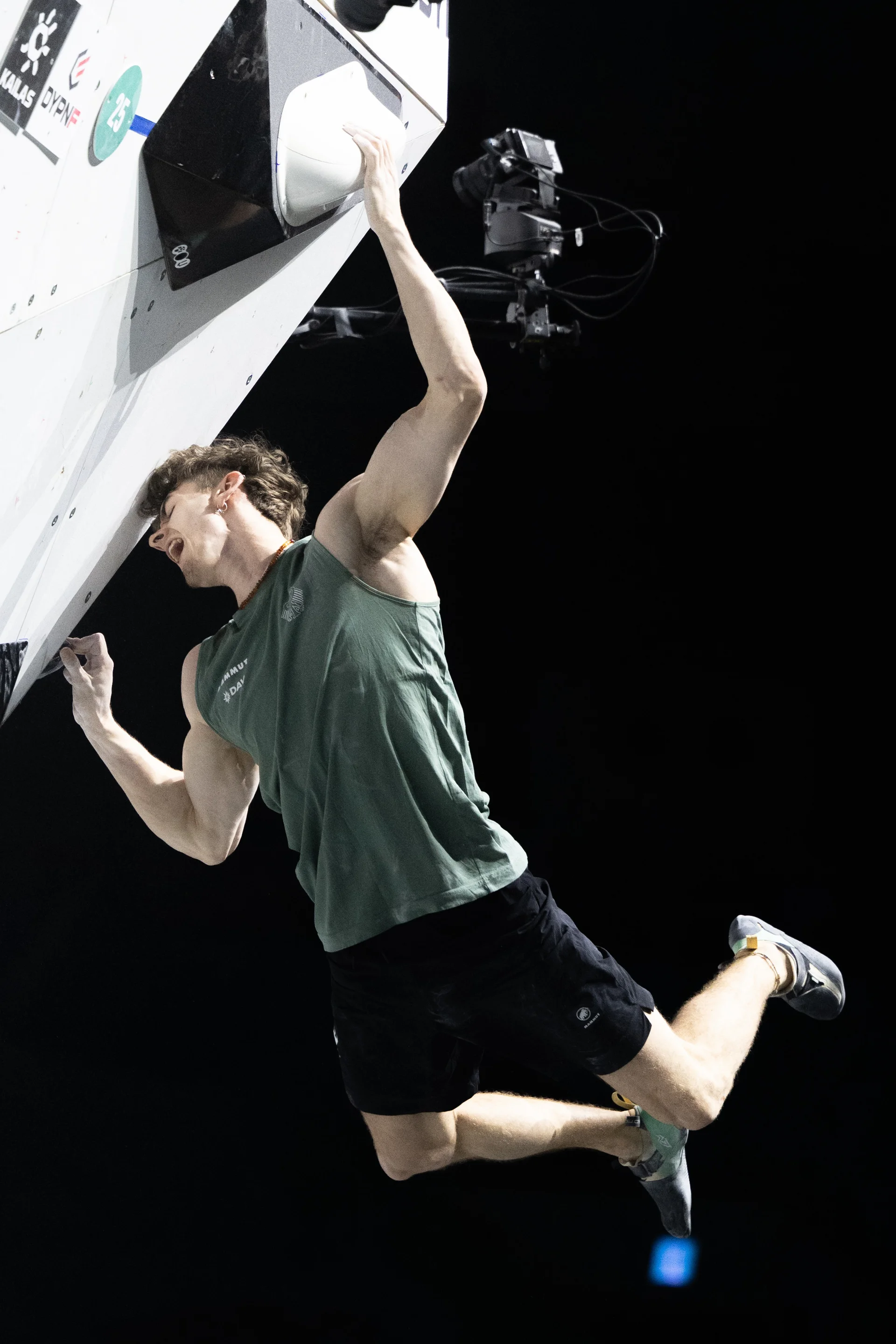 Thorben hängt in einem steilen Boulder, beide Beine pendeln dabei aus der Wand. | © Kazushige Nakajima/IFSC