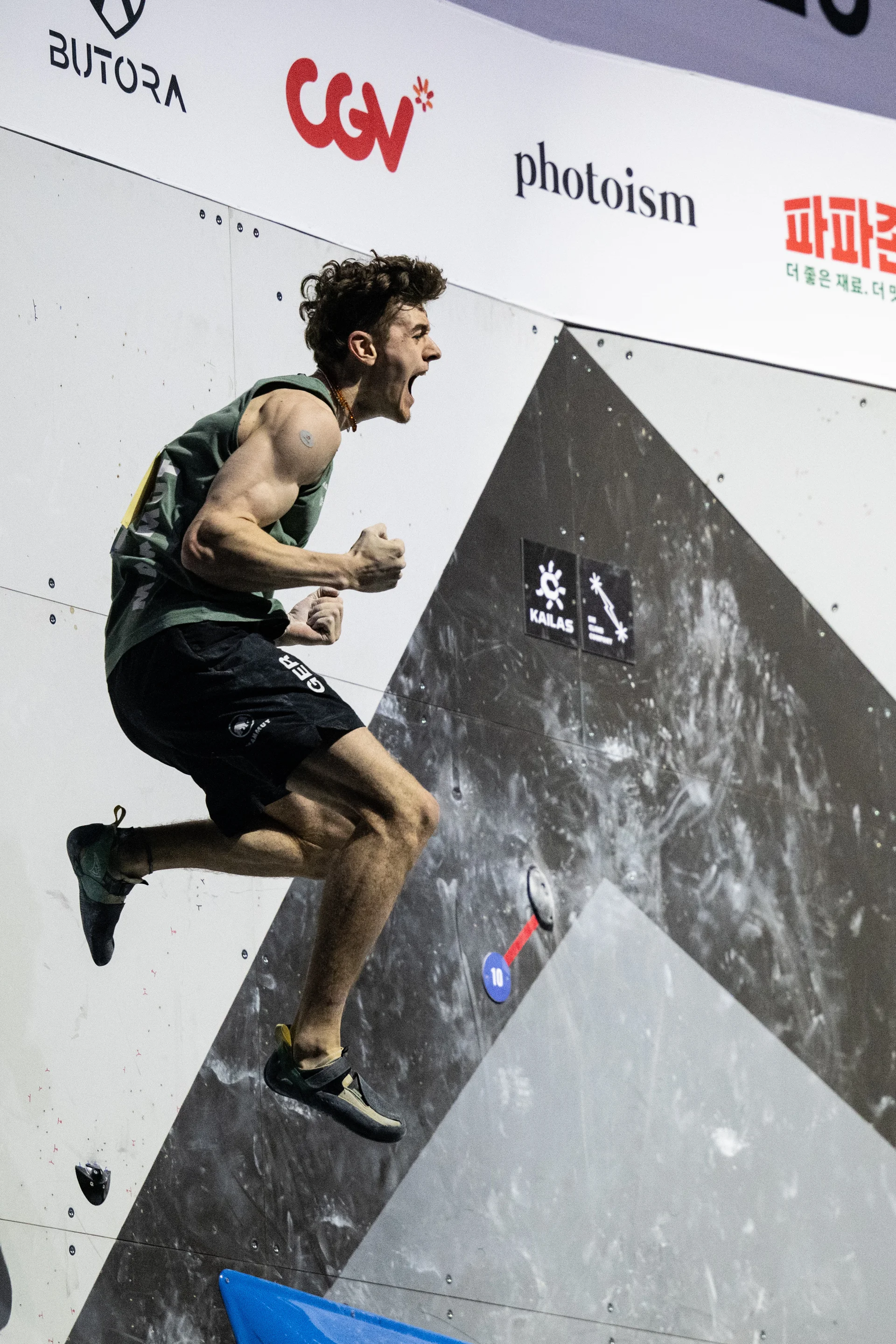 Thorben springt nach einem "getoppten" Boulder in Siegerpose von der Wand. | © Kazushige Nakajima/IFSC