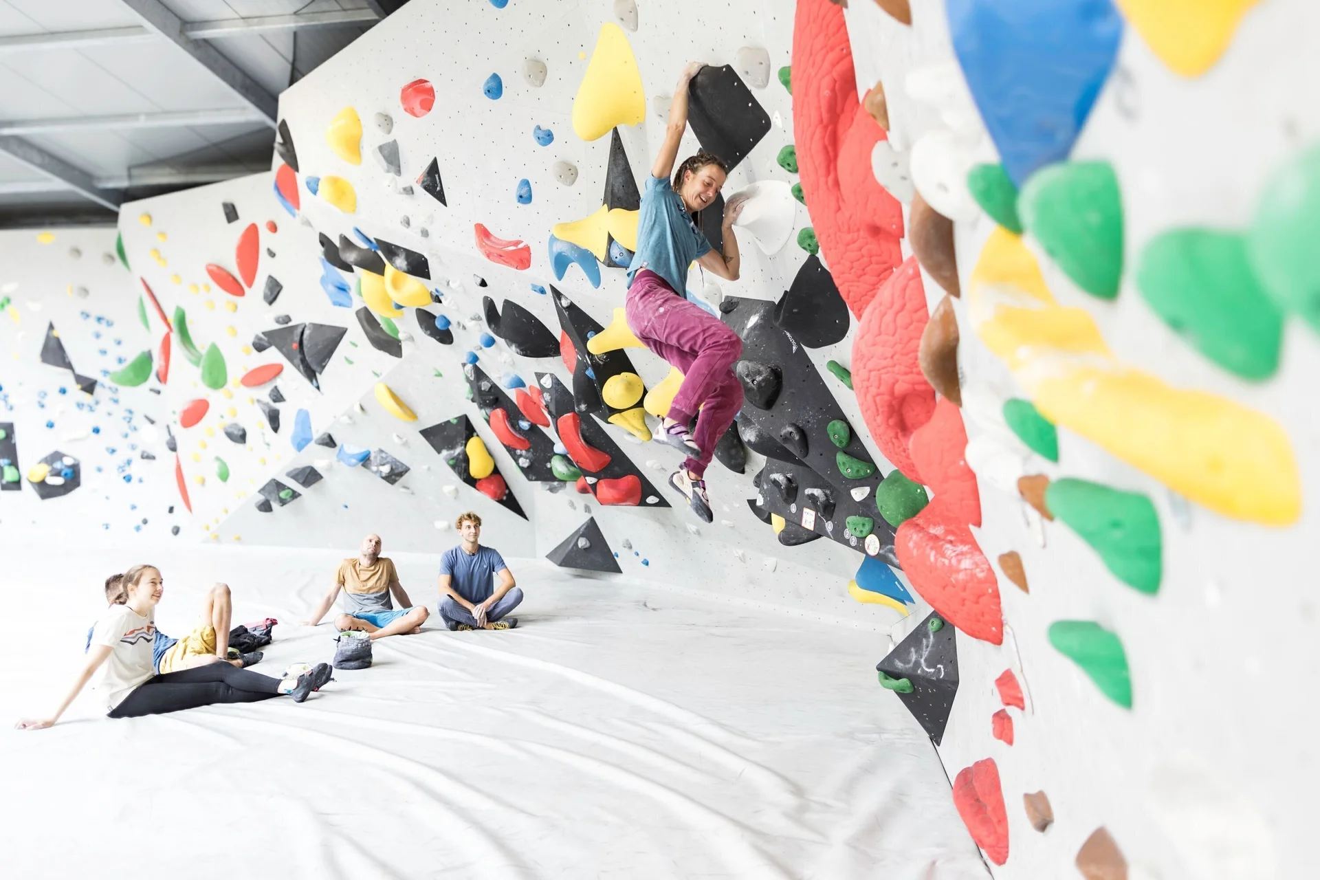Eine Frau beim Bouldern, im Hintergrund warten weitere Personen, bis sie an der Reihe sind | © DAV / Jens Klatt