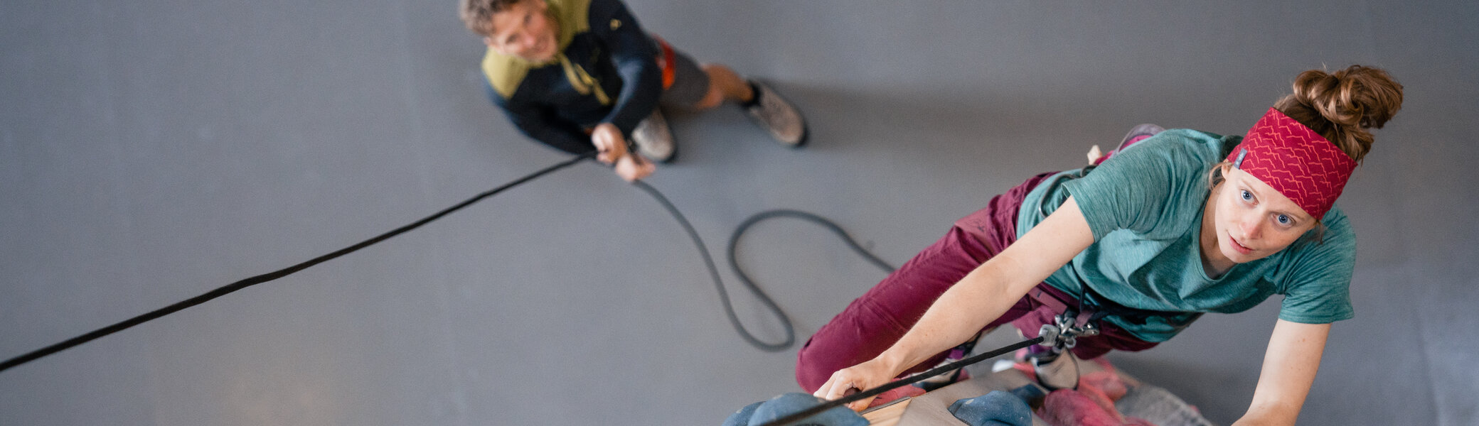 Eine Frau klettert in einer Kletterhalle, ihr Partner sichert sie. | © DAV/Marisa Koch