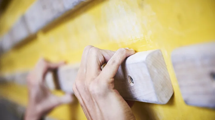 DAV Kletterhalle | © DAV/Frank Kretschmann Hände greifen nach Holzelementen an einer Kletterwand | © DAV/Frank Kretschmann